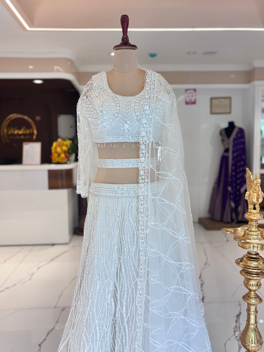 Ivory lehenga with belt and delicate embroidery.