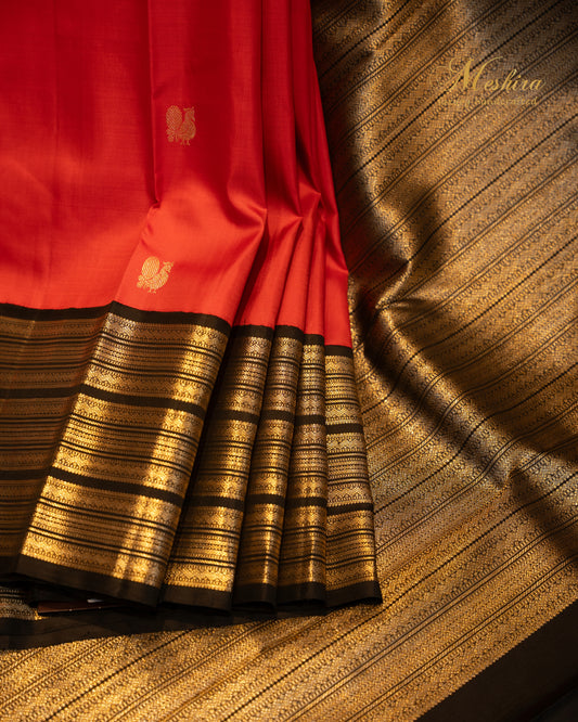 Crimson red Kanchivaram silk saree with black striped silver zari border.