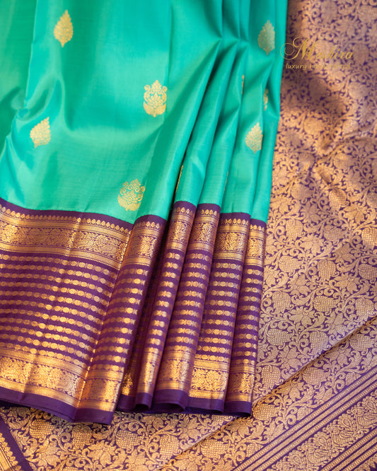 Turquoise blue Kanchivaram silk saree with zari motifs and contrast deep plum border