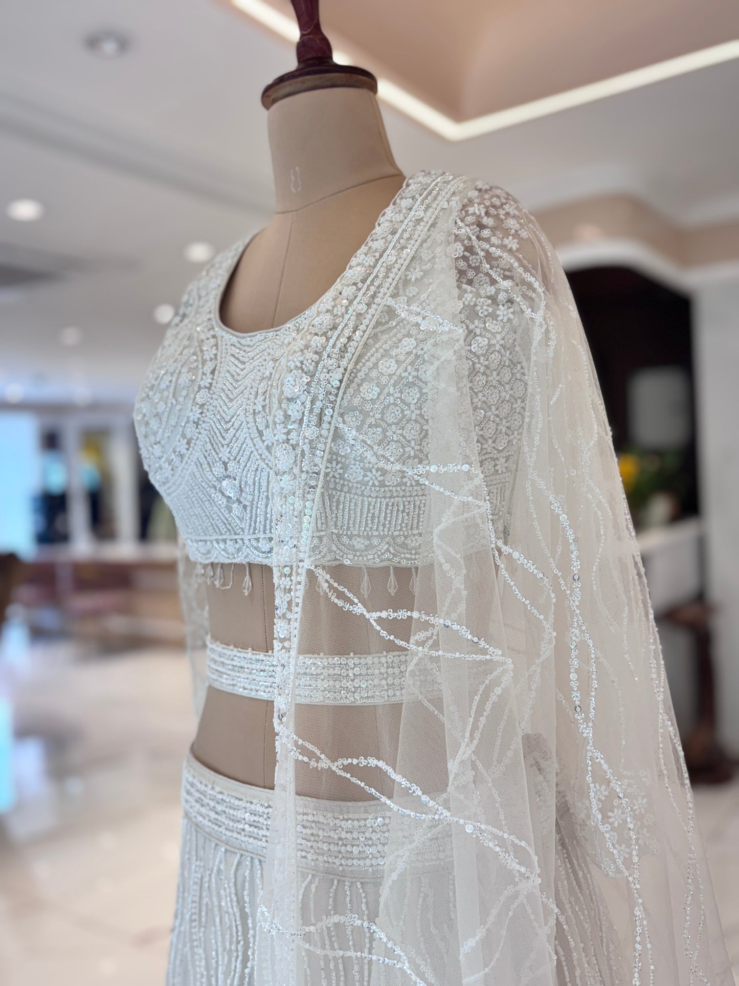 Ivory lehenga with belt and delicate embroidery.