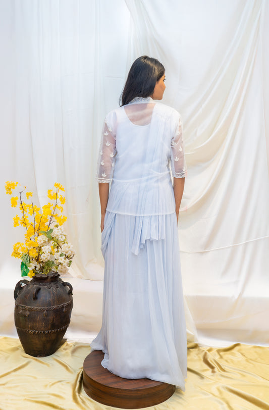 An elegant pastel blue draped gown paired with a delicately embroidered sheer jacket.