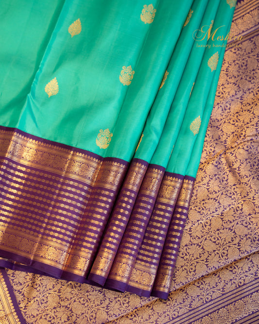 Turquoise blue Kanchivaram silk saree with zari motifs and contrast deep plum border