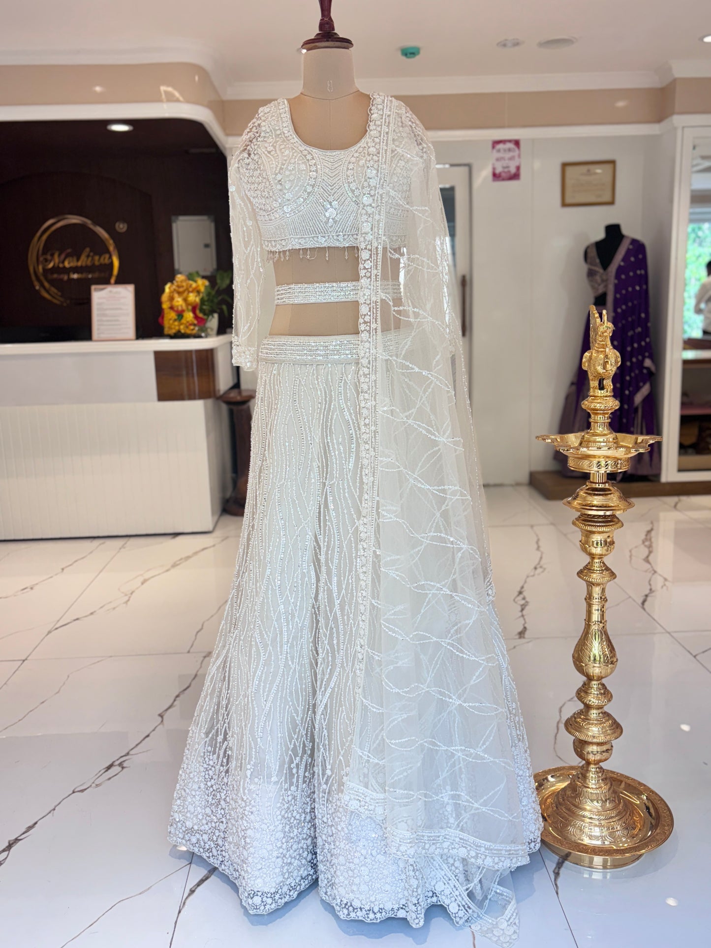 Ivory lehenga with belt and delicate embroidery.