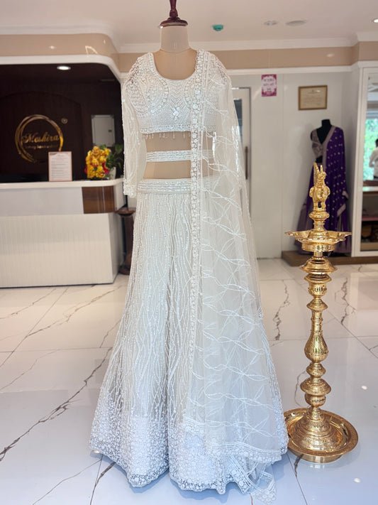Ivory lehenga with belt and delicate embroidery.