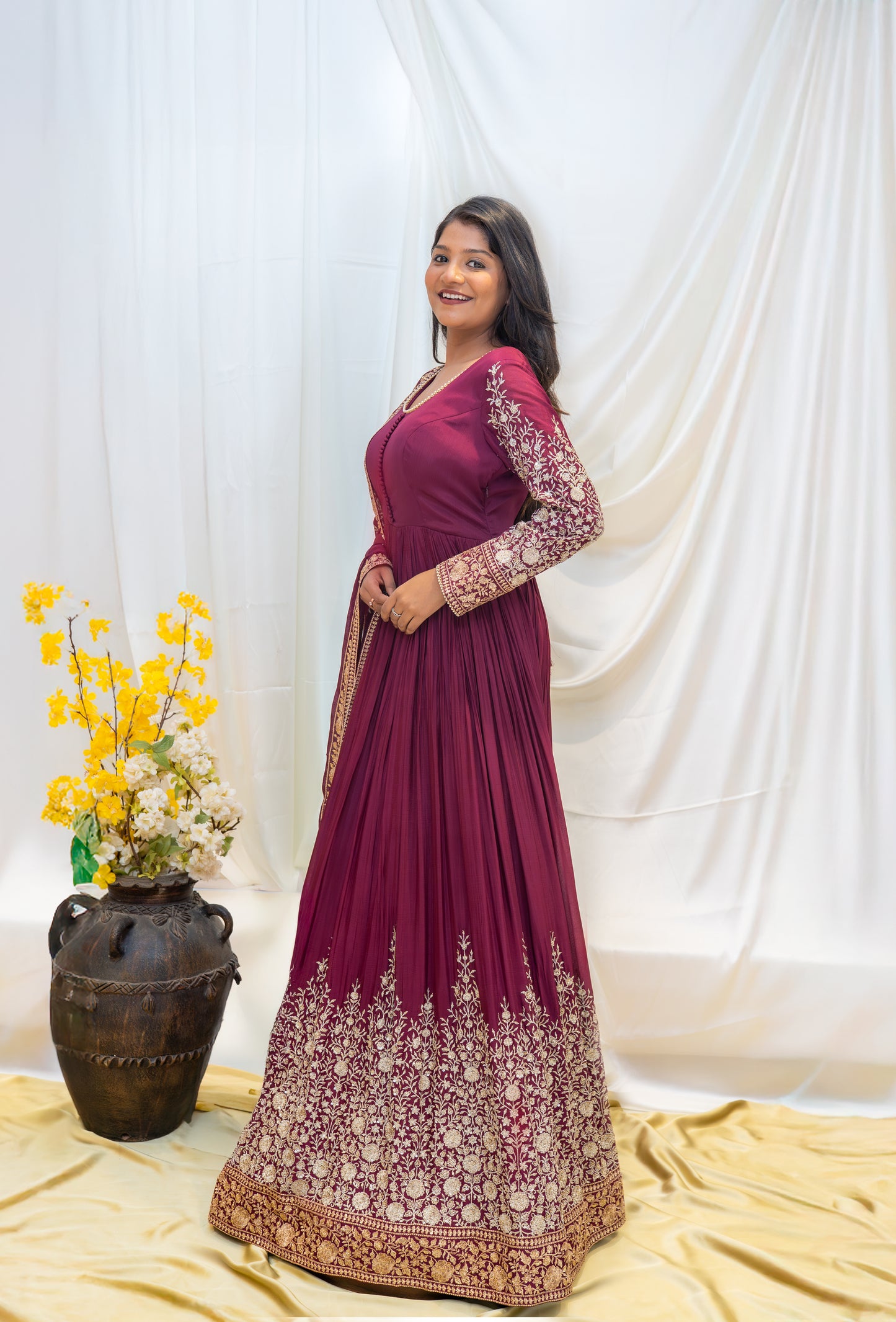 A regal maroon Anarkali enriched with intricate golden embroidery