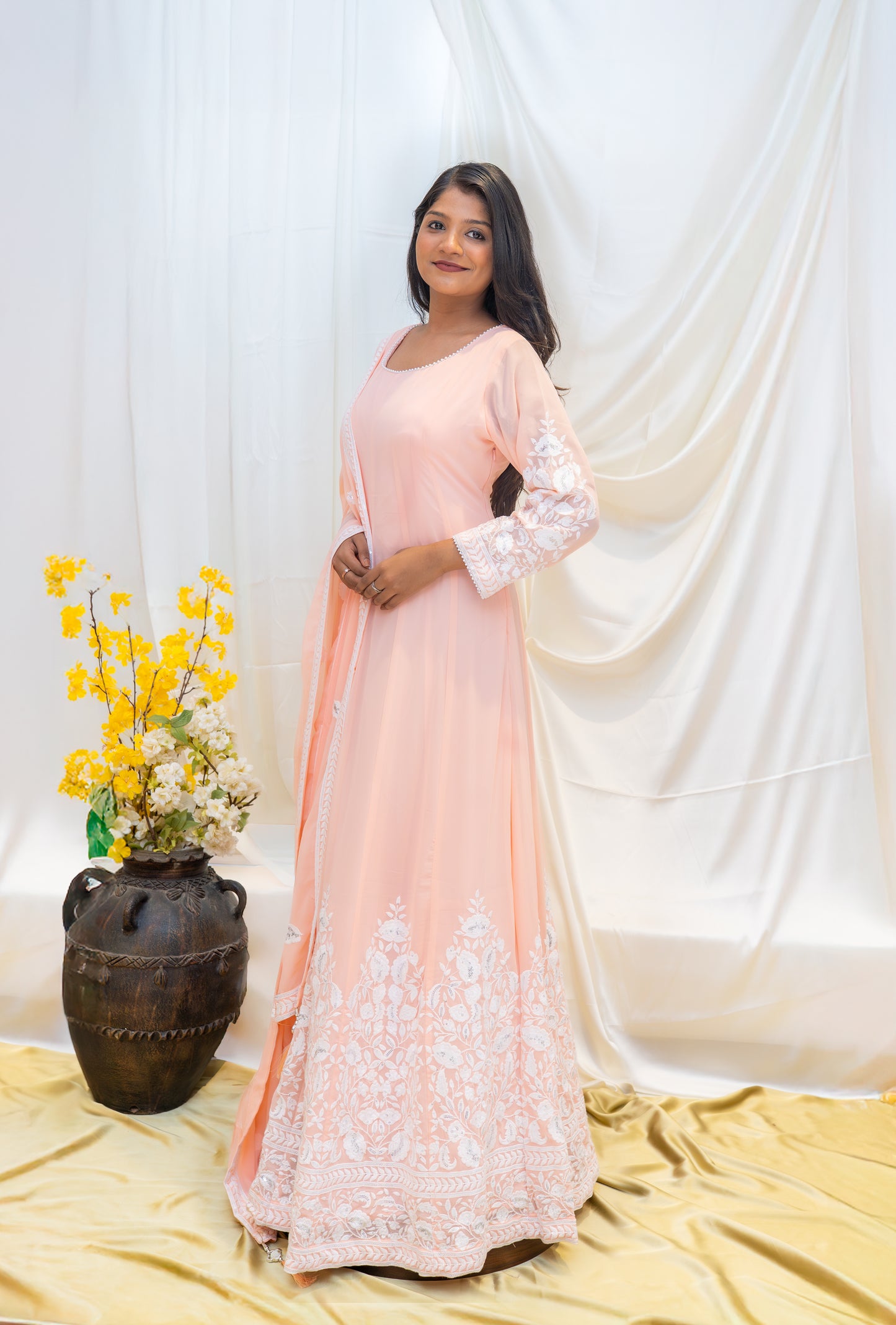 A soft peach Anarkali adorned with delicate white thread embroider